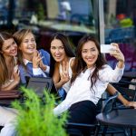 Four women sitting in a cafe on the street